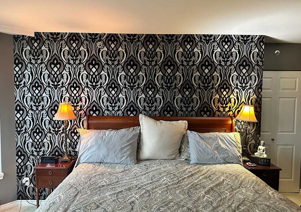 black-silver-damask-wallpaper-feature-wall Bedroom feature wall in bold black and silver damask wallpaper, with the large pattern matched across the full width behind the bed